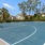a tennis court with trees and houses in the background