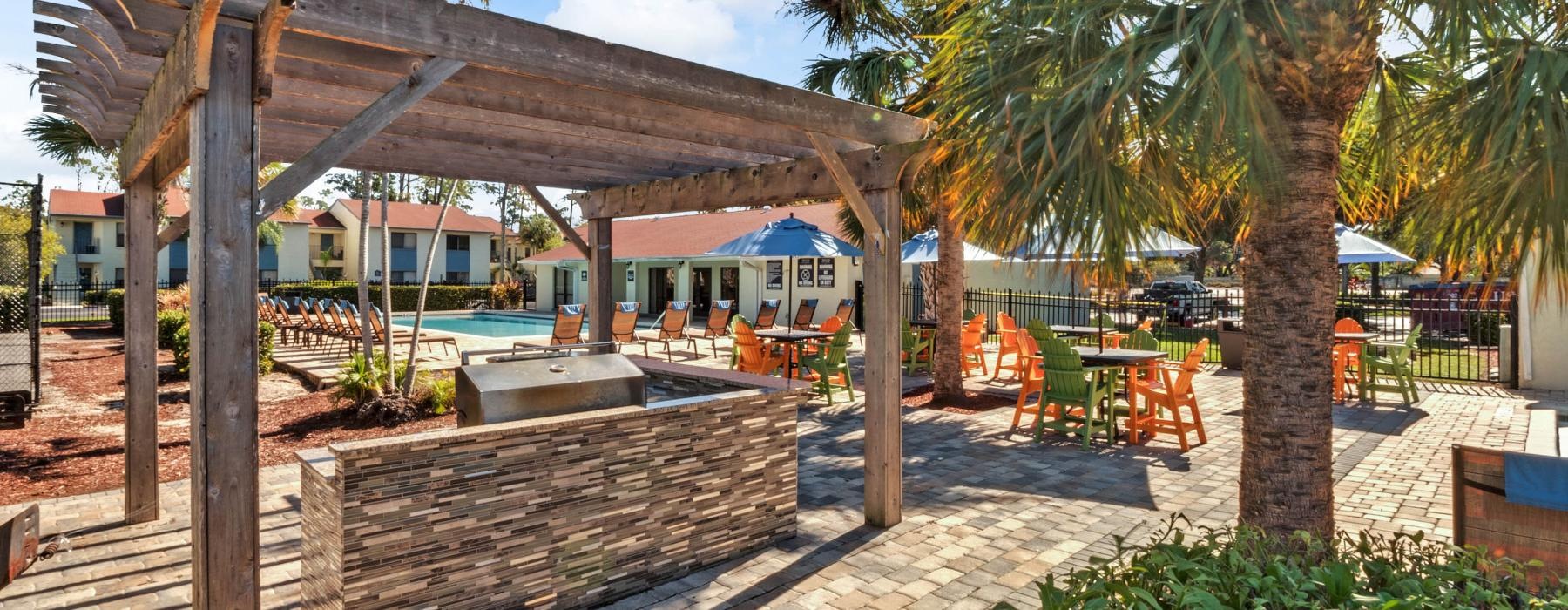 a patio with a hammock and a pool with a building in the background